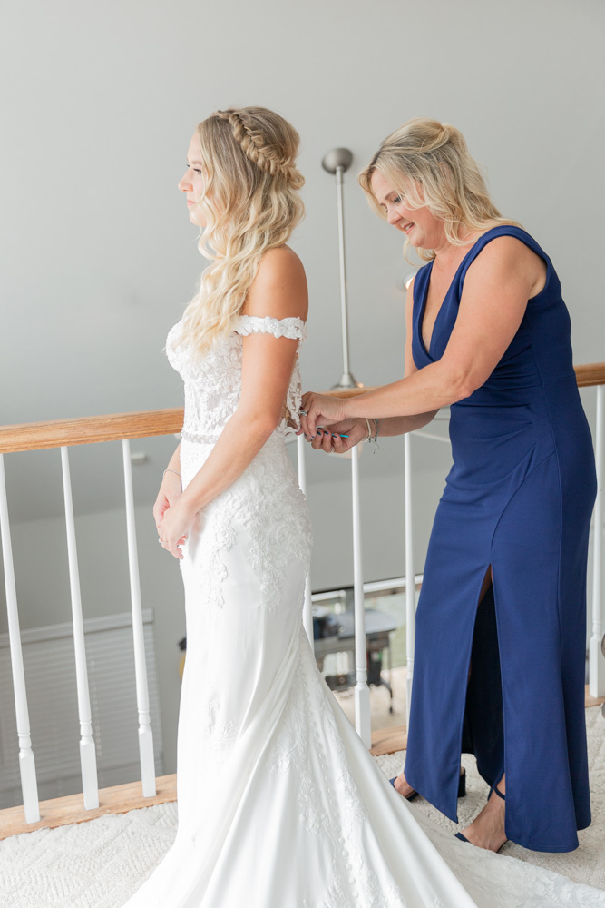 Mom buttoning bridal gown with crochet hook