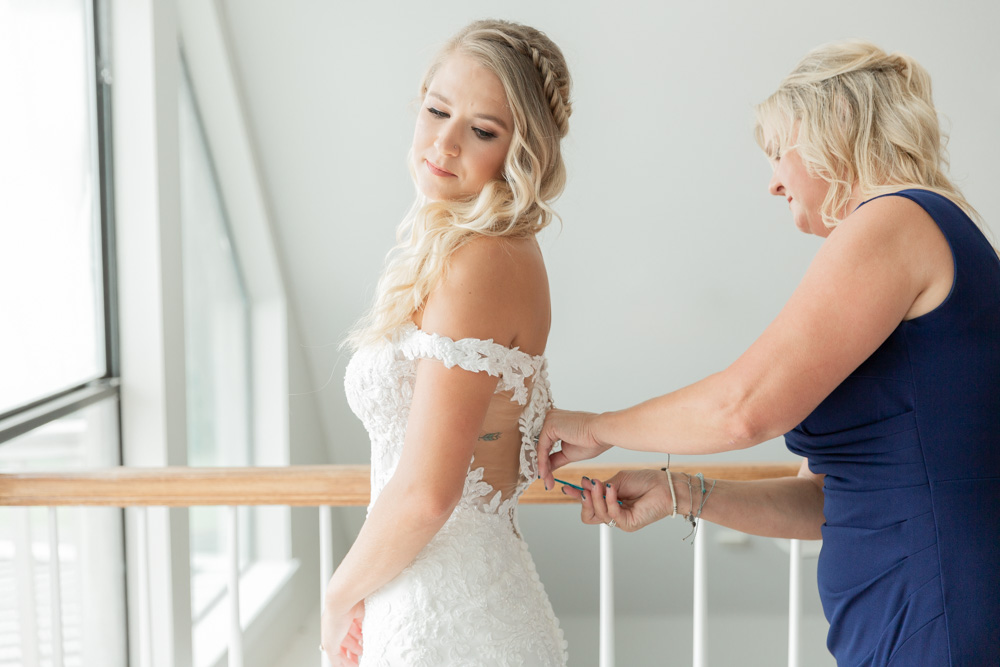 Mom buttoning wedding gown