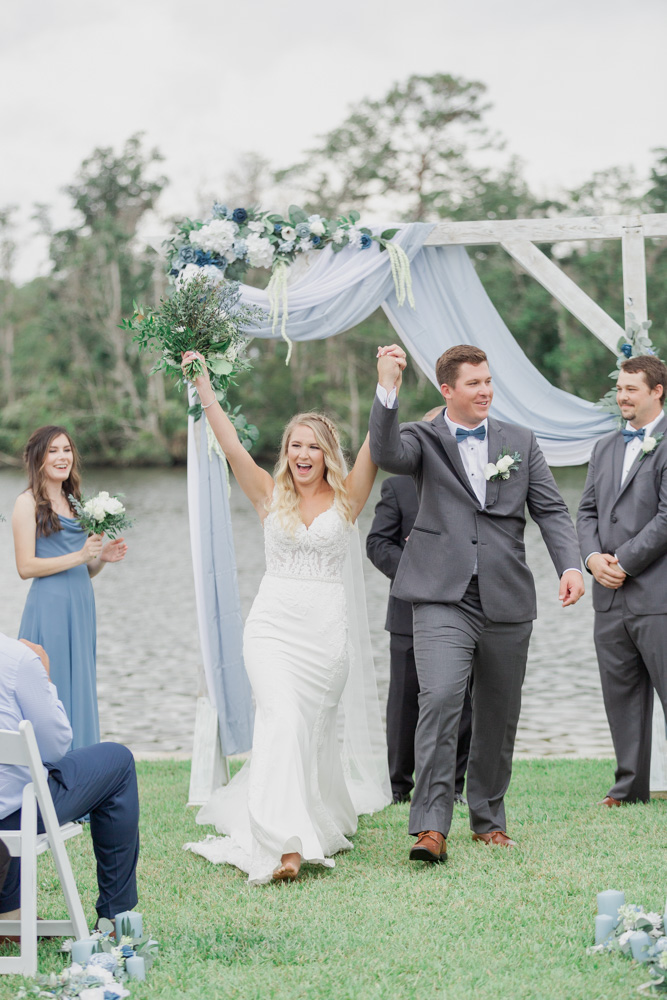 Just married cheering walking down aisle | Bride and groom happy