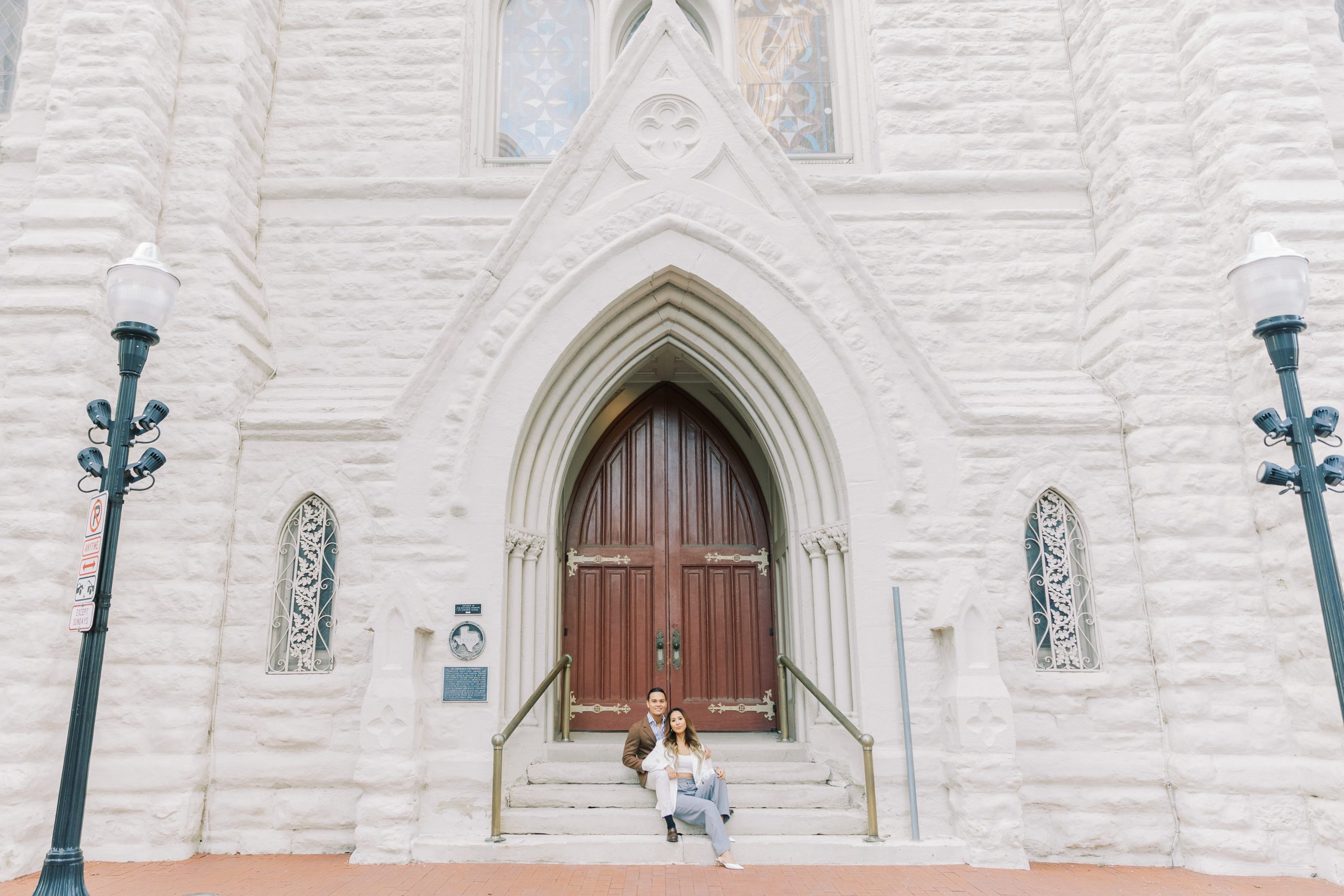 Asian couple sitting on steps of building for engagement session in downtown 